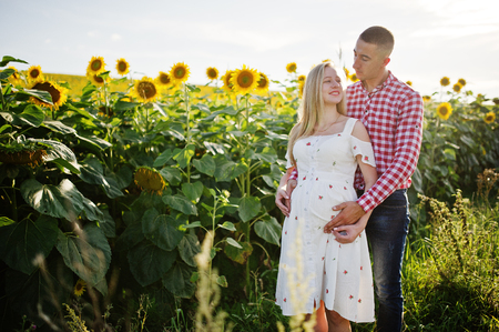 Pregnant couple in sunflowers field. Happy moments of pregnancy.の写真素材
