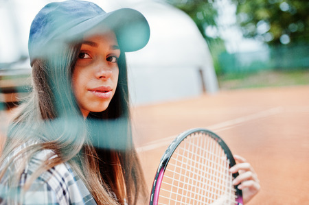 Young sporty girl player with tennis racket on tennis court.の写真素材