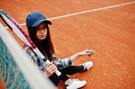 Young sporty girl player with tennis racket on tennis court.の写真素材