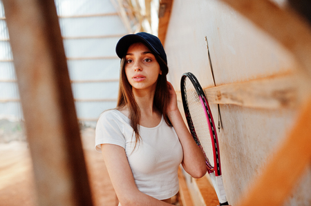 Young sporty girl player with tennis racket on tennis court.の写真素材