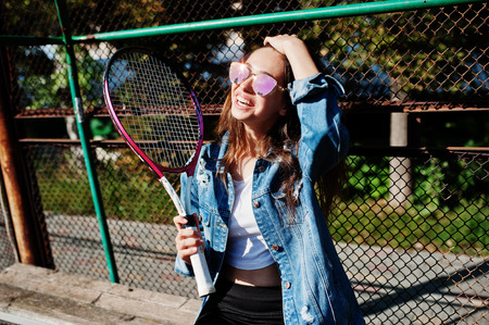 Young sporty girl player with tennis racket on tennis court.の写真素材