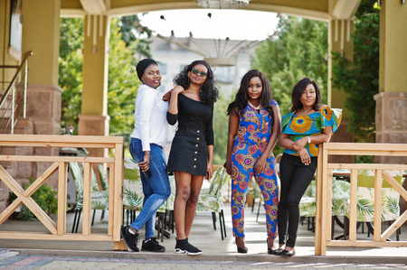 Group of four african american girls posed outdoor against city restaurant summer terrace.の写真素材