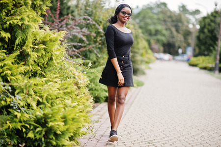 African american girl in sunglasses, black clothes and shirt posed outdoor. Fashionable black woman.の写真素材