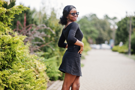 African american girl in sunglasses, black clothes and shirt posed outdoor. Fashionable black woman.の写真素材