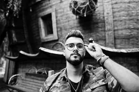 Close up portrait of awesome beautiful tall ararbian beard macho man in glasses and military jacket...