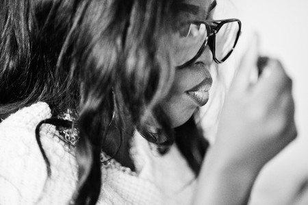 Stylish african american girl in sunglasses posed at modern cafe and eating ice cream.の写真素材