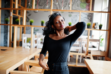 African american girl posed at wooden modern cafe.の写真素材