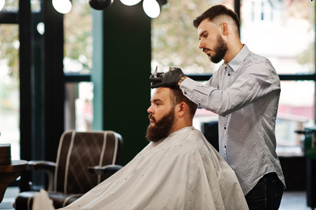 Handsome bearded man at the barbershop, barber at work.の写真素材