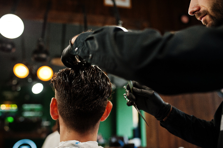 Handsome bearded man at the barbershop, barber at work.の写真素材