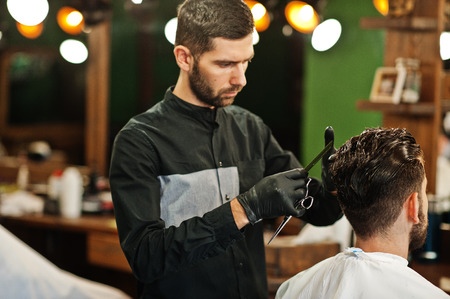 Handsome bearded man at the barbershop, barber at work.の写真素材
