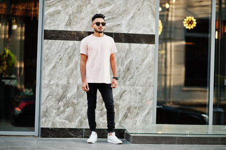 Stylish indian beard man at sunglasses and pink t-shirt. India model posed outdoor at streets of city.の写真素材