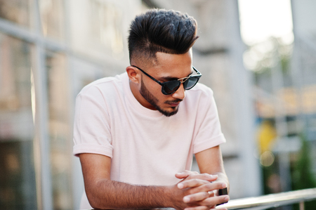 Stylish indian beard man at sunglasses and pink t-shirt. India model posed outdoor at streets of city.の写真素材