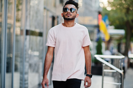Stylish indian beard man at sunglasses and pink t-shirt. India model posed outdoor at streets of city.の写真素材