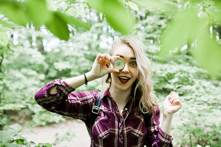 Portrait of an attractive blond girl posing with a compass in a forest.の写真素材