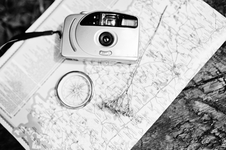 Close-up photo of compass laying on the map next to the camera.の写真素材