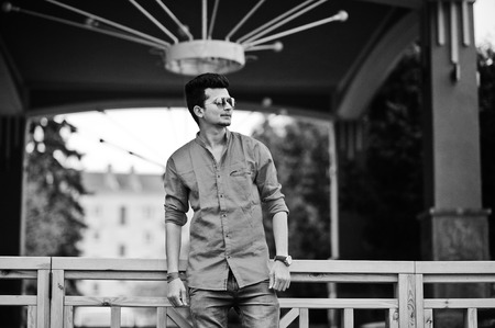 Indian man at red shirt and sunglasses posed outdoor. Black and white photo.の写真素材