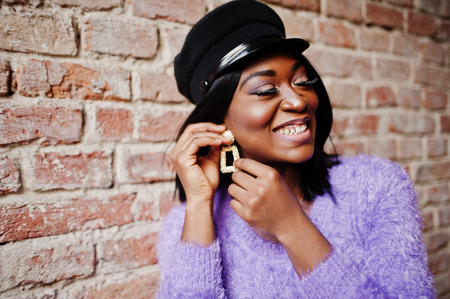 Close up portrait of african american woman at violet dress and cap posed outdoor.