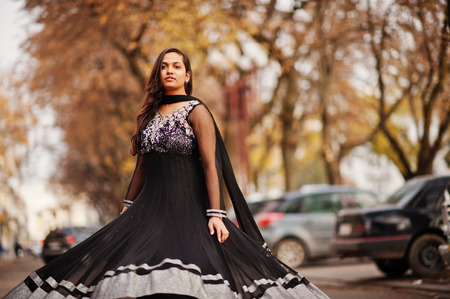 Pretty indian girl in black saree dress posed outdoor at autumn street.の写真素材