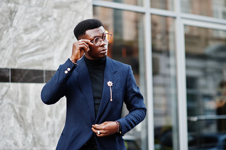 Amazingly looking african american man wear at blue blazer with brooch, black turtleneck and glasses posed at street. Fashionable black guy.の写真素材