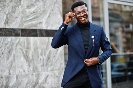 Amazingly looking african american man wear at blue blazer with brooch, black turtleneck and glasses posed at street. Fashionable black guy.の写真素材