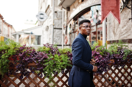 Amazingly looking african american man wear at blue blazer with brooch, black turtleneck and glasses posed at street. Fashionable black guy.の写真素材