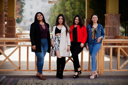 Group of four happy and pretty latino girls from Ecuador posed at street.の写真素材