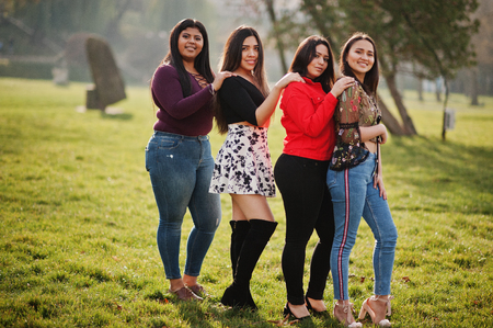 Group of four happy and pretty latino girls from Ecuador posed at street.の写真素材