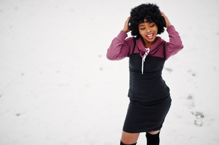 Curly hair african american woman posed at winter day. Afro model girl against snow.