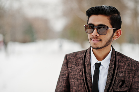 Close up portrait of stylish indian student man in suit and sunglasses posed at winter day outdoor.の写真素材