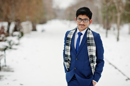 Stylish indian student man in suit, glasses and scarf posed at winter day outdoor.の写真素材