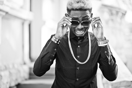 Chic handsome african american man in black shirt with gold chain and sunglasses.の写真素材