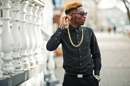 Chic handsome african american man in black shirt with gold chain and sunglasses.の写真素材