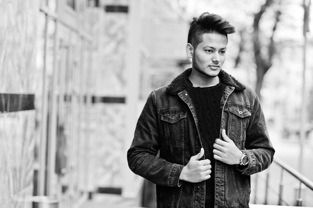 Handsome and fashionable indian man in black jeans jacket posed outdoor.の写真素材