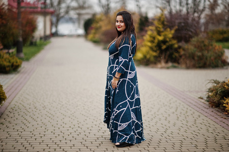 Brunette indian woman in long fashionable dress posed outdoor.の写真素材