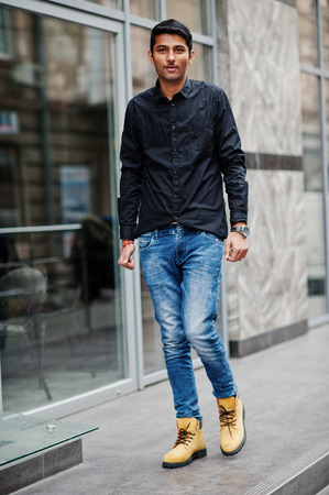 Stylish indian model man in casual clothes, black shirt posed outdoor at street of India.の写真素材
