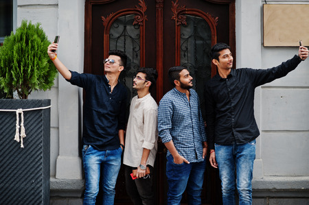 Group of four indian ethnicity friendship togetherness mans. Technology and leisure, guys with...