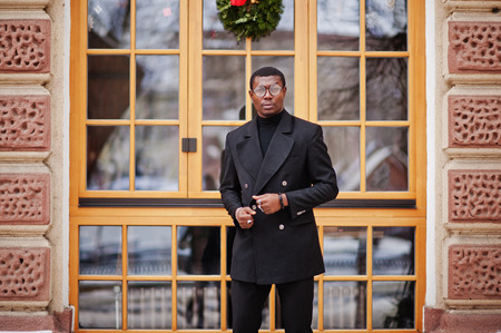 Stylish african american gentleman in elegant black jacket. Rich fashionable afro man against...