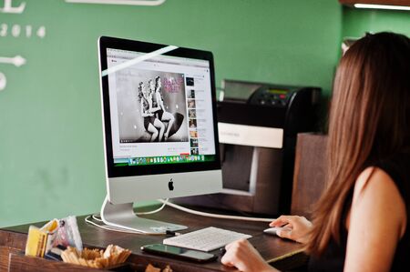 Kyiv, Ukraine - January 20, 2018: Girl sitting against Apple imac in office and looking You Tube...