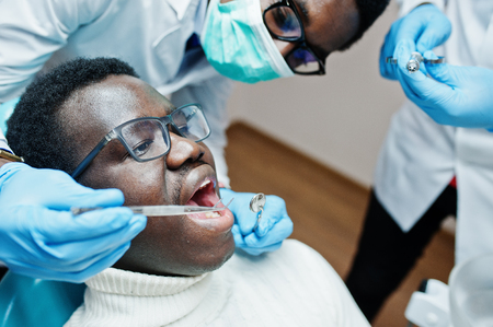 African american man patient in dental chair. Dentist office and doctor practice concept....