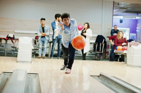 South asian man in jeans shirt standing at bowling alley and throw ball in air.の写真素材