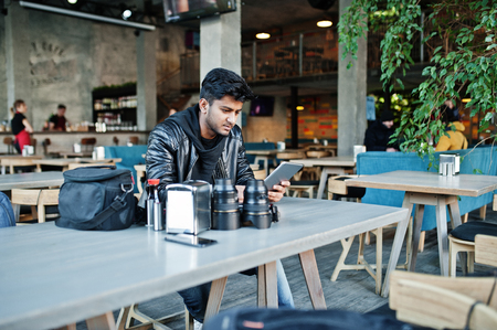 Smart young asian man photographer working with tablet during sitting at cafe.の写真素材