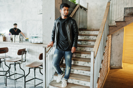Casual and stylish young asian man wear on leather jacket standing on stairs at cafe.の写真素材