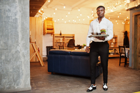 Young african american waiter man hold tray with burger at restaurant.