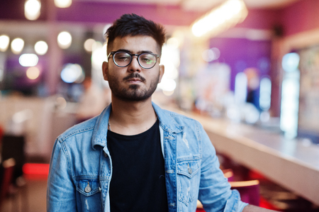 Stylish asian man wear on jeans jacket and glasses posed against bar in club.の写真素材