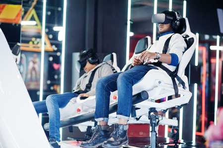 Two young indian people having fun with a new technology of a vr headset at virtual reality...