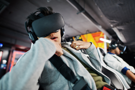Two young indian people having fun with a new technology of a vr headset at virtual reality...