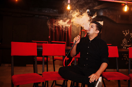 Asian man smoke hookah and having rest at lounge bar.の写真素材