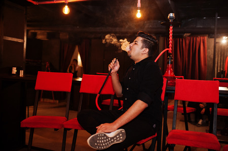 Asian man smoke hookah and having rest at lounge bar.の写真素材