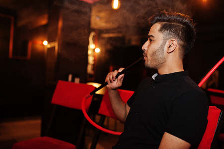 Asian man smoke hookah and having rest at lounge bar.