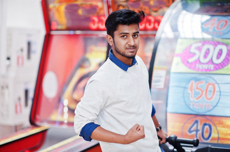 Young asian man play on fortune wheel slot machines to try win at lottery great prize. Gamble jackpot prize spin. Round drum casino money game.の写真素材